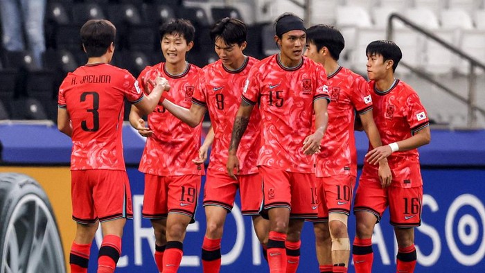 South Koreas midfielder #19 Min-Woo Kim reacts as his players celebrate after he scored their first goal during the AFC U23 Asian Cup Qatar 2024 Group B match between Korea and Japan at Jassim Bin Hamad Stadium in Doha on April 22, 2024. (Photo by KARIM JAAFAR / AFP)
