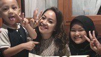 Pelantun Mati Rasa ini tengah berpose dengan dua anaknya. Tampak di hadapan mereka ada selusin donat aneka rasa dan kue ulang tahun. Foto: Instagram nina_mpokalpa