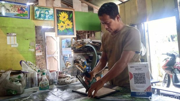 M Irwan pemilik Irjie Kaligrafi saat mengerjakan orderan (Andika Syahputra/detikcom)