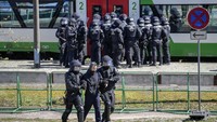 Polisi dengan perlengkapan antihuru-hara menunggu di luar kereta sementara para “hooligan” ditahan di dalam. Mereka dikeluarkan satu per satu untuk diproses. Petugas polisi di kedua sisi seseorang akan mencengkeram orang tersebut dengan memegang tangan mereka dalam posisi yang tidak wajar untuk mencegah mereka melarikan diri.  