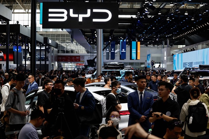 A staff member cleans a Xiaomi SU7 electric vehicle displayed at the Beijing International Automotive Exhibition, or Auto China 2024, in Beijing, China, April 25, 2024. REUTERS/Tingshu Wang