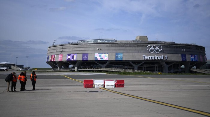Gendarmes pose in front of the Charles de Gaulle airport, terminal 1, where the olympic rings were installed, in Roissy-en-France, north of Paris, Tuesday, April 23, 2024 in Paris. (AP Photo/Thibault Camus)