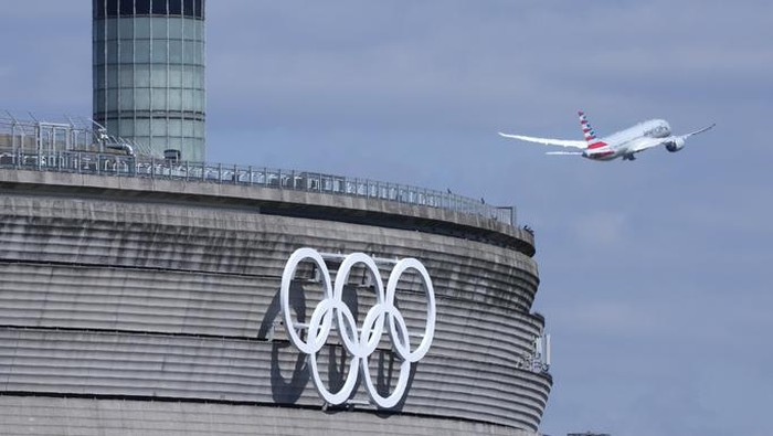 Gendarmes pose in front of the Charles de Gaulle airport, terminal 1, where the olympic rings were installed, in Roissy-en-France, north of Paris, Tuesday, April 23, 2024 in Paris. (AP Photo/Thibault Camus)