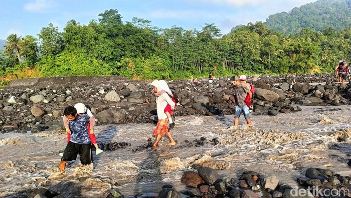 Perjuangan Ayah Gendong Anak Sembrangi Aliran Lahar Semeru Antar ke Sekolah Sejumlah siswa harus digendong ayahnya menyebrangi Sungai Leprak, Desa Jugosari, Kecamatan Candipuro, Kabupaten Lumajang untuk berangkat ke sekolah di SDN Jugosari 03, Kamis
(25/4/2024). Mereka harus menyebrangi sungai akibat jembatan limpas tertimbun material lahar dingin Semeru.