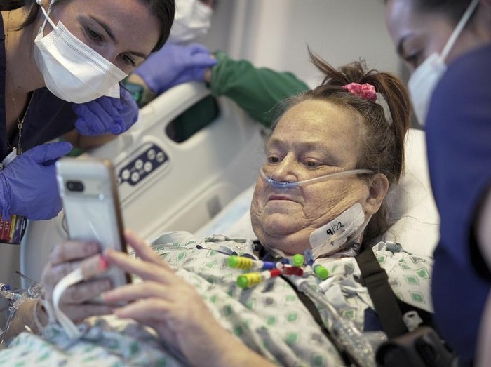 Lisa Pisano steps back into her bed while recovering from her surgeries at NYU Langone Health in New York on Monday, April 22, 2024. Doctors transplanted a pig kidney into Pisano, who was near death, part of a dramatic pair of surgeries that also included a fix for her failing heart. (AP Photo/Shelby Lum)