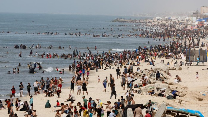 Warga Gaza Tenangkan Diri Sejenak di Pantai Rafah, Israel Marah Palestinians enjoy the beach on a hot day, amid the ongoing conflict between Israel and Hamas, in Rafah, in the southern Gaza Strip, April 24, 2024. REUTERS/Mohammed Salem TPX IMAGES OF THE DAY