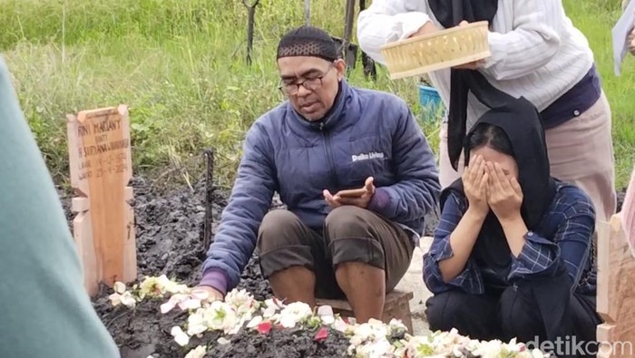 Anak Rini Mariany (berkerudung hitam) saat pemakaman di TPU Rancacili, Kota Bandung. Jasad Rini diketahui ditemukan di dalam koper di wilayah Cikarang, Bekasi.