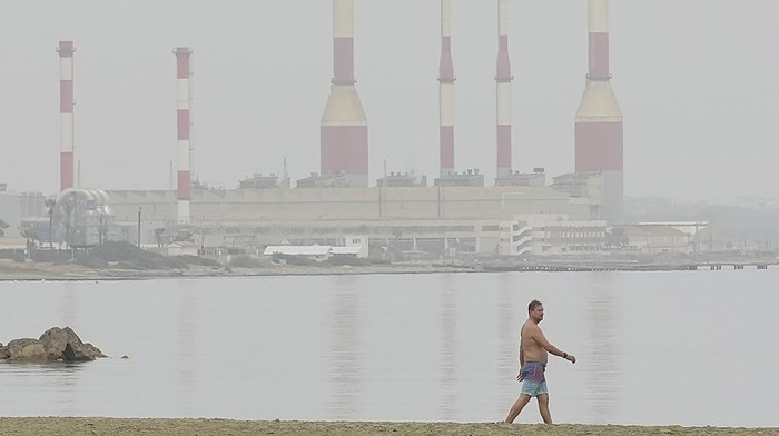 Kabut Debu Selimuti Kota Pesisir di Siprus A man walks at the beach through a haze caused by dust, near southern coastal city of Larnaca, in the southeast Mediterranean island of Cyprus, on Thursday, April 25, 2024. A low-pressure system in North Africa is affecting the area with winds and dust. (AP Photo/Petros Karadjias)