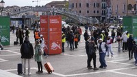 Pramugara memeriksa akses kode QR wisatawan di luar stasiun kereta utama di Venesia, Italia, Kamis (25/4/2024). Kota laguna Venesia memulai program percontohan pada hari Kamis untuk membebankan biaya masuk sebesar 5 euro atau sekitar Rp 87.000 kepada pelancong harian. Hal ini dalam upaya mengurangi kerumunan yang memadati kanal selama puncak musim liburan.
