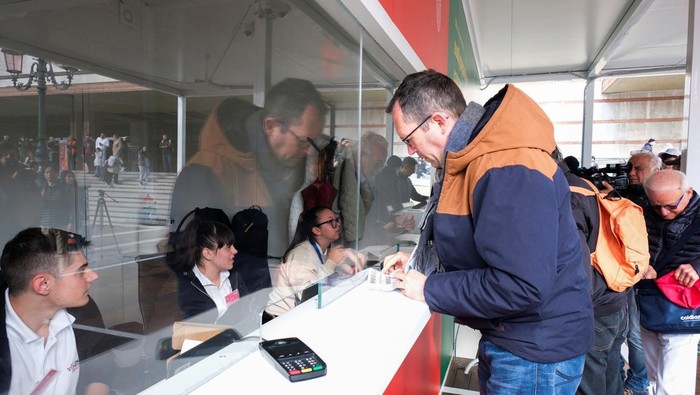 Tourists queue at the information center to register and receive a QR code to prove their payment of a fee for day trippers introduced by Venice municipality in a move to preserve the lagoon city often crammed with tourists in Venice, Italy, April 25, 2024. REUTERS/Manuel Silvestri