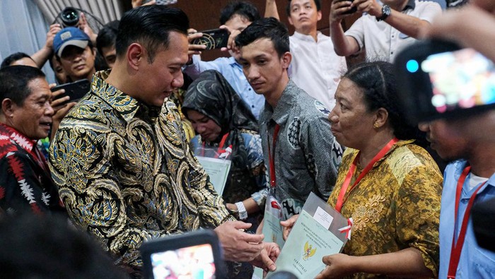 AHY Bagi-bagi Sertifikat Tanah di Kendari Menteri Agraria dan Tata Ruang/Badan Pertanahan Nasional (ATR/BPN) Agus Harimurti Yudhoyono (kiri) menyerahkan sertifikat tanah secara gratis kepada warga di Kendari, Sulawesi Tenggara, Jumat (26/4/2024). Sebanyak 300 dari total 11.819 sertifikat tanah diserahkan secara simbolis kepada warga yang berhak dalam program pendaftaran tanah sistematis lengkap (PTSL). ANTARA FOTO/Andry Denisah/YU/nym.