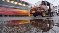 Sebuah angkot  terparkir kawasan Terminal Joyoboyo yang disalip oleh Bus Suroboyo.