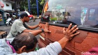 Beberapa orang mendorong angkot yang mogok di sekitar Terminal Joyoboyo.