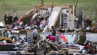 Warga bahu-membahu menyingkirkan puing-puing bangunan. Nikos Frazier/Omaha World-Herald via AP.
