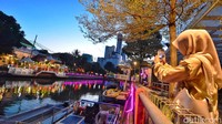 Seorang pengunjung sedang mengabadikan momen senja di Sungai Kalimas.