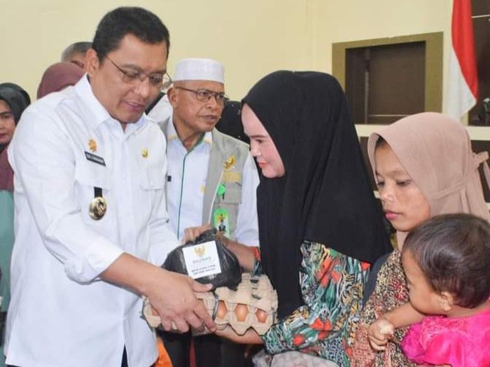 Pj Bupati Palas Edy Junaedi Harahap saat memberikan bantuan ke warga