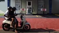 Pengendara sepeda motor berhenti di depan Stasiun Pengisian Kendaraan Listrik Umum (SPKLU) di Ternate, Maluku Utara, Jumat (26/4/2024).