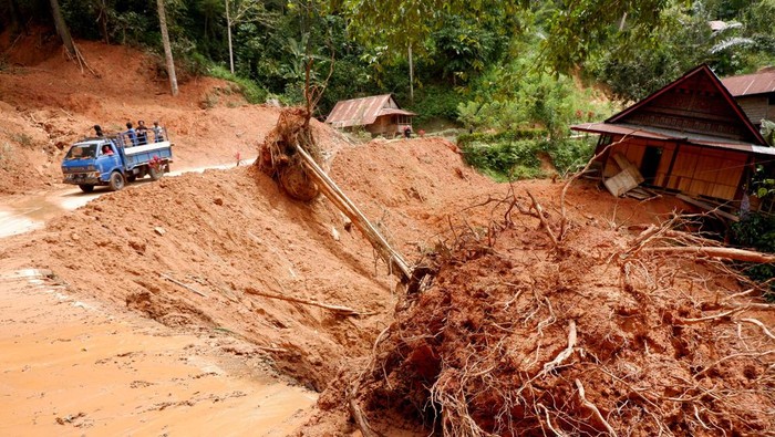 Warga melintas di area terdampak tanah longsor di Kelurahan Tallang Sura, Buntao, Kabupaten Toraja Utara, Sulawesi Selatan, Minggu (28/4/2024). Tanah longsor yang terjadi pada jumat (26/4) tersebut mengakibatkan sedikitnya sembilan pengendara yang melintas tertimbun material longsor, tiga diantaranya meninggal dunia dan enam orang sementara dalam perawatam di rumah sakit. ANTARA FOTO/Sakti Karuru/rwa.