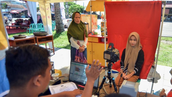 Pelajar melakukan perekaman KTP elektronik di Pantai Purus, Padang, Sumatera Barat, Minggu (28/4/2024). 
Dinas Kependudukan dan Pencatatan Sipil (Disdukcapil) Kota Padang membuka layanan perekaman KTP elektronik atau e-KTP pada hari libur sekaligus layanan aktivasi Identitas Kependudukan Digital (IKD). ANTARA FOTO/Iggoy el Fitra/rwa.