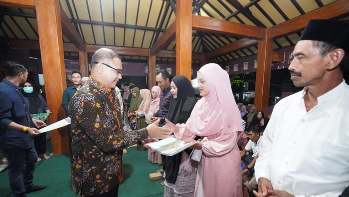Pj Wali Kota Batu Aries Agung Paewai menyerahkan sertifikat tanah ke warga