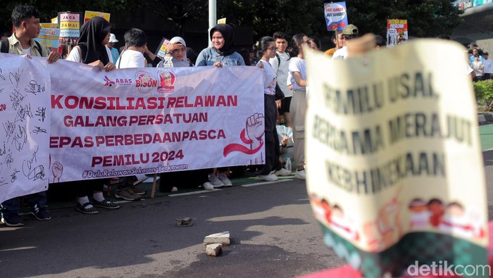 Sejumlah relawan lintas capres dan cawapres menggelar aksi di CFD Jakarta. Mereka menyerukan persatuan antar pendukung capres-cawapres usai Pemilu 2024.