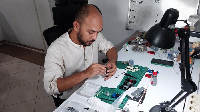 Haqi saat bergelut dengan miniatur mobil ciptaannya