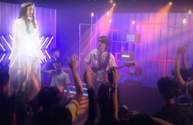 Pada lagu kedua berjudul Fortuna, Iqbaal tampil bak penyanyi cafe. Ia bernyanyi di tengah-tengah kerumunan banyak orang yang turut berjoget menikmati lagunya. Foto: YouTube/Iqbaal Ramadhan