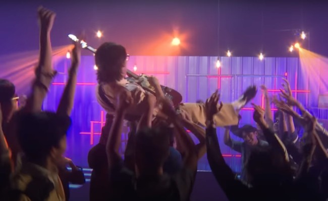 Di akhir video klip Fortuna, Iqbaal tampak digotong beramai-ramai oleh para penontonnya. Sambil bermain gitar, Iqbaal tetap terus bernyanyi. Foto: YouTube/Iqbaal Ramadhan