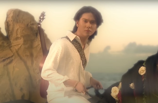 Di lagu ketiga yang berjudul Di Bawah Lampu, Iqbaal tampil bak seorang pangeran berkuda. Mengenakan pakaian serba putih sambil menggendong gitar, Iqbaal menunggangi seekor kuda hitam. Foto: YouTube/Iqbaal Ramadhan