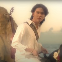 Di lagu ketiga yang berjudul Di Bawah Lampu, Iqbaal tampil bak seorang pangeran berkuda. Mengenakan pakaian serba putih sambil menggendong gitar, Iqbaal menunggangi seekor kuda hitam. Foto: YouTube/Iqbaal Ramadhan