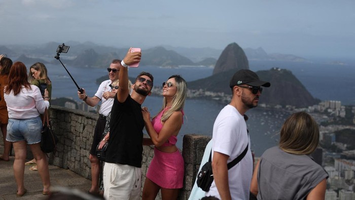 Menikmati Panorama Kota Rio de Janeiro Brasil dari Ketinggian A couple takes a selfie from the Dona Marta lookout point in Rio de Janeiro, Brazil April 26, 2024. REUTERS/Pilar Olivares