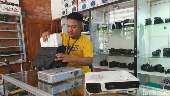 Salah seorang pemilik persewaan proyektor di Gunungkidul, Riyan Andi Setiyawan, menyiapkan proyektor untuk warga yang sedang memesan, Senin (29/4/2024).