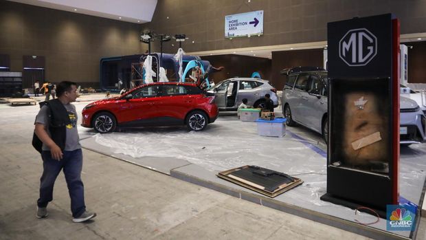 Pekerja menyelesaikan pembuatan tenant jelang berlangsungnya acara Periklindo Electric Vehicle Show (PEVS) di JIExpo Kemayoran, Jakarta, Senin (29/4/2024). (վ/Faisal Rahman)