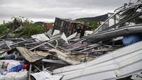 Selain membuat atap bangunan ambruk, badai tornadi juga mengakibatkan truk trailer terguling. Deng Hua/Xinhua via AP.