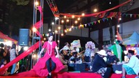 8 penari yang menari selama 24 jam berada di panggung tersendiri yang dikeliling bazar makanan dan diiringi musik band. Sambil berkumpul, penari juga bersantai bahkan sambil makan. (Foto: Luthfi Zian Nasifah/detikEdu)