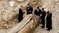 Warga Yahudi Ultra Ortodoks terlihat berkeliaran di sekitar sisa-sisa rudal balistik Iran di dekat kota Arad di selatan Israel.