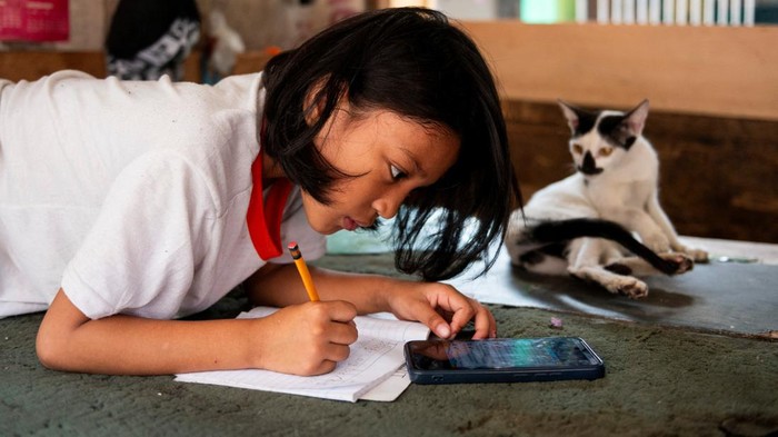 A student answers his learning module following the suspension of in-person classes, inside his house in Manila, Philippines, April 26, 2024. REUTERS/Lisa Marie David
