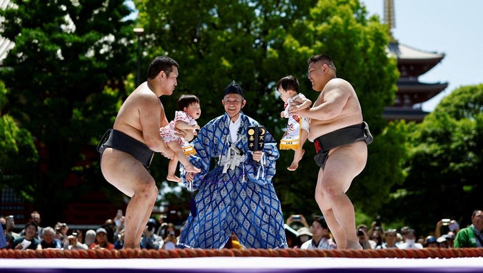 Ritual Unik Bayi Sumo Menangis di Jepang Amateur sumo wrestlers hold babies during 'Nakizumo' or a baby-crying sumo contest, where two wrestlers hold a baby each and a referee makes faces and loud noises to make them cry and determine the winner based on the loudest baby, at Sensoji temple in Tokyo, Japan, April 28, 2024. The ritual is believed to aid the healthy growth of the children and ward off evil spirits. REUTERS/Issei Kato TPX IMAGES OF THE DAY