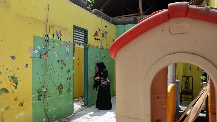 Guru PAUD membersihkan puing bangunan yang roboh di Sekolah PAUD kelompok bermain (Kober) Permata Hati di Desa Langkapsari, Kabupaten Ciamis, Jawa Barat, Senin (29/4/2024). Akibat gempa bumi berkekuatan 6,5 di barat daya Garut ditambah hujan deras pada Sabtu (27/4) malam, mengakibatkan bangunan sekolah roboh dan terpaksa siswa PAUD mengikuti kegiatan belajar mengajar di Madrsah. ANTARA FOTO/Adeng Bustomi/foc.