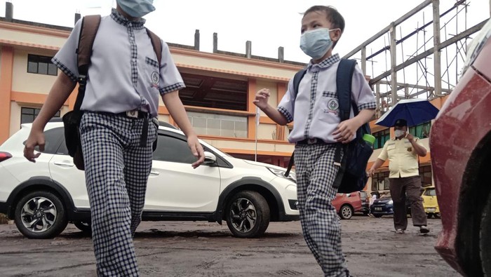 Siswa-siswi Dipulangkan Gegara Sekolah Terdampak Erupsi Gunung Ruang Siswi mengenakan masker sambil melihat abu vulkanik yang mengenai sepeda motornya di Manado, Sulawesi Utara, Selasa (30/4/2024). Dampak material erupsi gunung Ruang di kabupaten Kepulauan Sitaro pada Selasa (30/4) dinihari, telah mencapai kota Manado yang mengakibatkan timbunan abu vulkanik setebal setengah centimeter sehingga sejumlah sekolah terpaksa memulangkan lebih awal siswanya. ANTARA FOTO/Yudi Makka/adw/YU