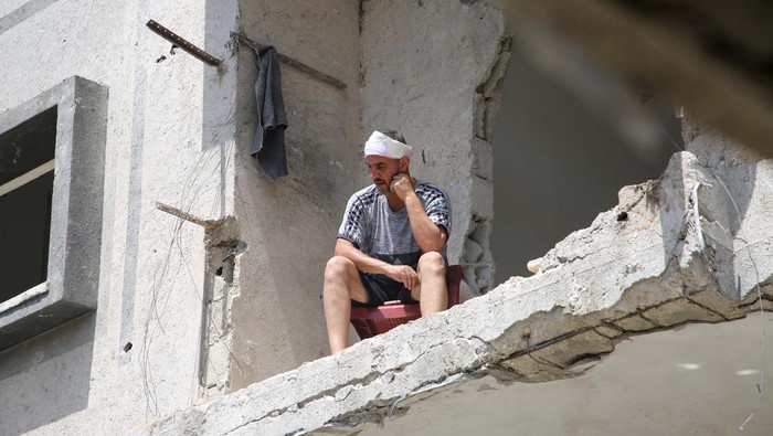 Tatapan Warga Gaza Melihat Puing-puing Bangunan Sisa Serangan Israel Palestinian Abdel Rahman Barika, who survived an Israeli air strike, looks from a damaged house at the site of an Israeli strike, amid the ongoing conflict between Israel and the Palestinian Islamist group Hamas, in Rafah, in the southern Gaza Strip, April 29, 2024. REUTERS/Hatem Khaled