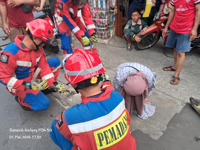 Damkar evakuasi kaki wanita yang terperosok di sela drainase daerah Kramat Jati (dok.Damkar Jakarta Timur)