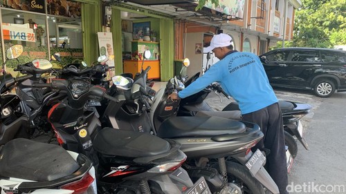 Seorang petugas parkir di kawasan pertokoan Jalan Diponegoro, Rabu (1/5/2024).