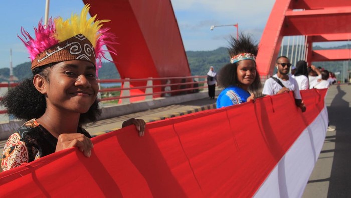 Siswa SMP membentangkan Bendera Merah Putih di  Jembatan Youtefa Holtekamp, Kota Jayapura, Papua, Rabu (1/5/2024). Pembetangan Bendera Merah Putih sepanjang 11.000 meter itu dalam rangka memperingati Hari Pembebasan Irian Barat atau Hari Integrasi Papua ke Indonesia. ANTARA FOTO/Gusti Tanati/tom.
