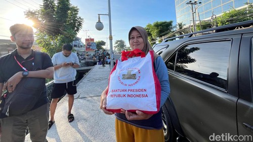 Salah satu warga yang menerima sembako dari Jokowi di Mataram, NTB, Rabu (1/5/2024).