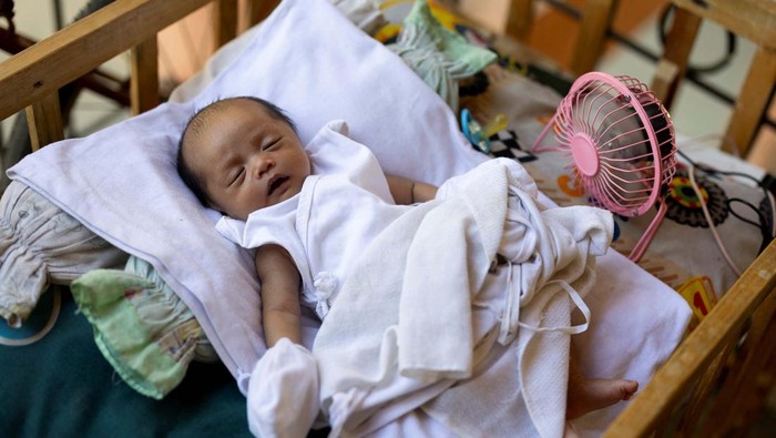 A mini fan spins beside a baby in a crib amid extreme heat in Valenzuela, Metro Manila, Philippines, May 2, 2024. REUTERS/Eloisa Lopez