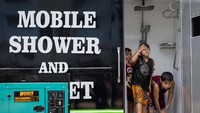 Anak-anak menggunakan mobile shower untuk mendinginkan diri di Valenzuela, Metro Manila, Filipina, 2 Mei 2024.  