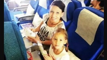 Foto seorang ibu dan anaknya menjelang keberangkatan pesawat Malaysia Airlines MH pada tahun 2014. Pesawat itu hancur ditembak di atas langit Ukraina. Foto: History Defined