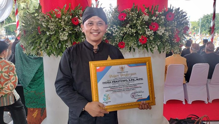 Indra Prastowo saat menerima penghargaan dari Gubernur Jatim
