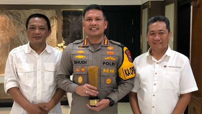 Kapolresta Malang Kota Kombes Budi Hermanto menerima trofi penghargaan dari PWI Jatim.